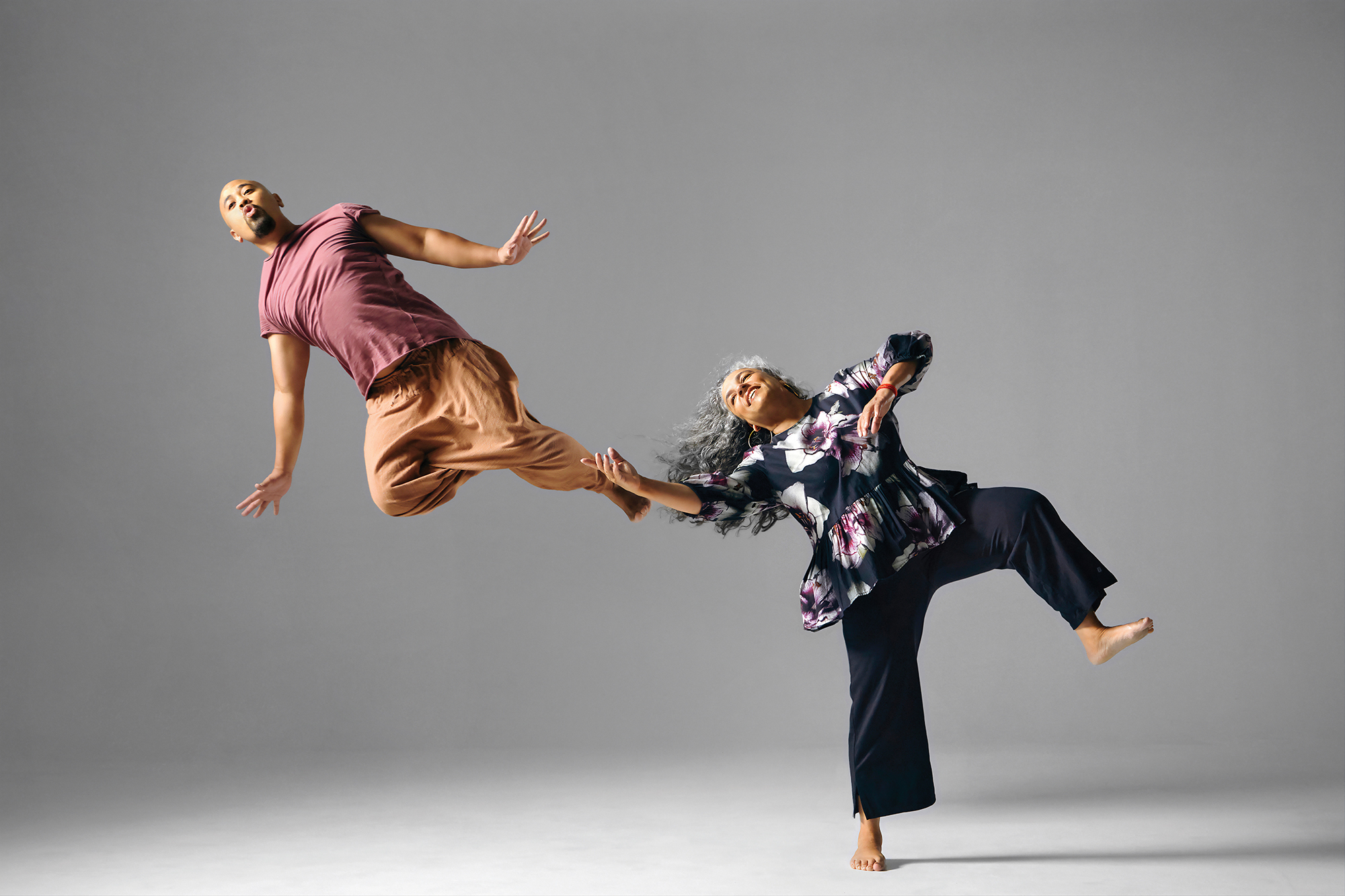Alumnus Jason Galeos and faculty member Michèle Moss leap with characteristic joy.
