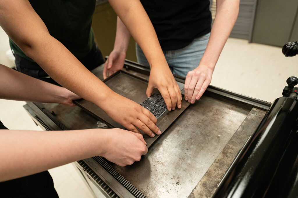 Three pairs of hands guide the text block of the finished sonnet 